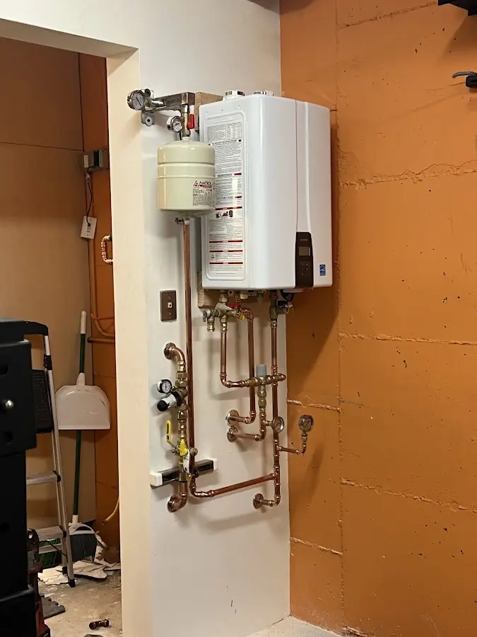 Plumbing technician inspecting water heater connections in Wilkinsburg